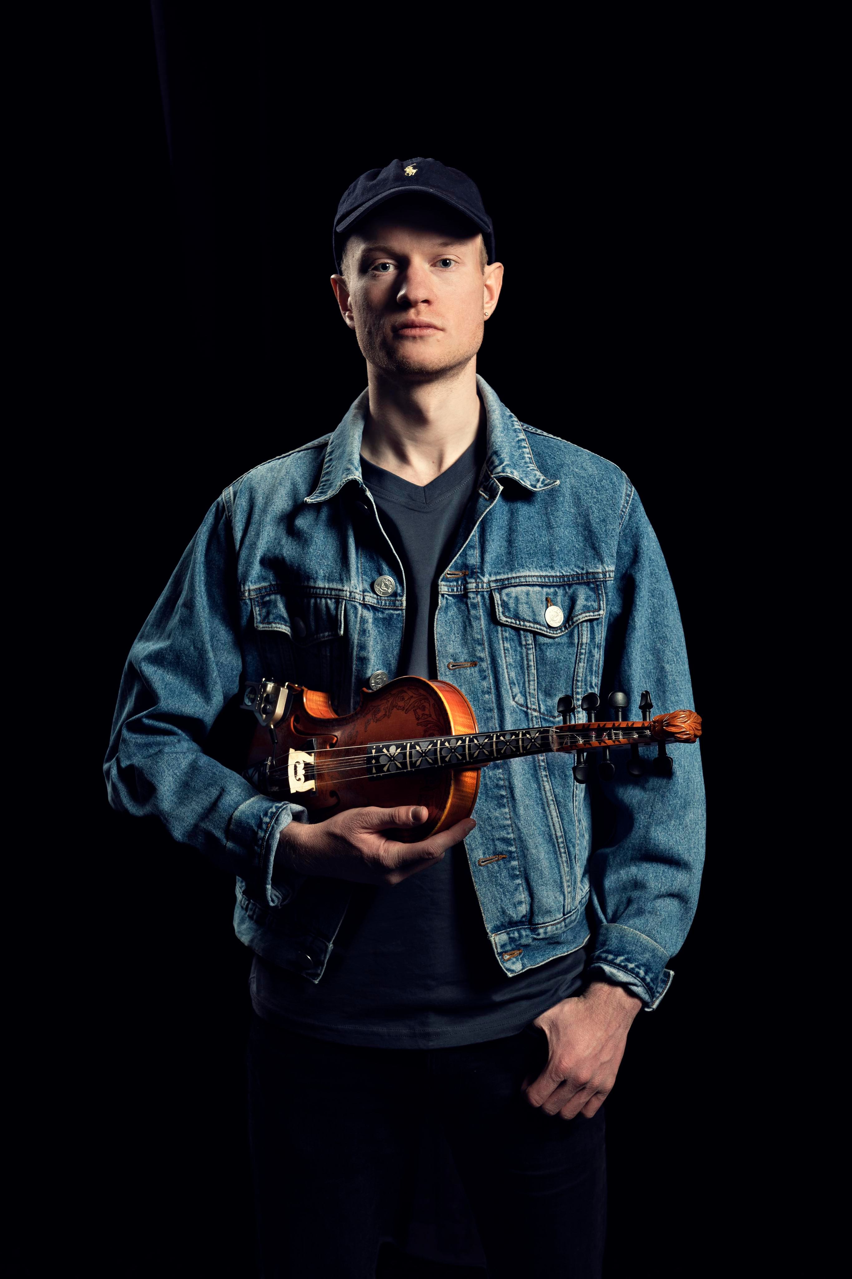 Mattias Thedens holding a Hardanger fiddle